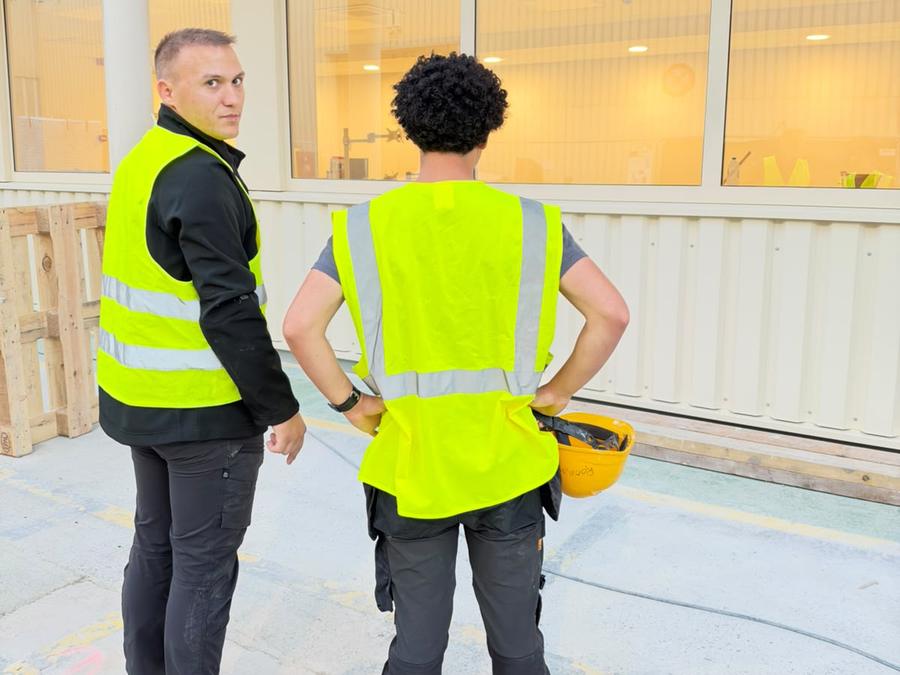 Équipe GomaClean sur un site professionnel, devant des baies vitrées